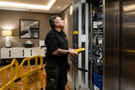 Technicien réparant un système d’ascenseur