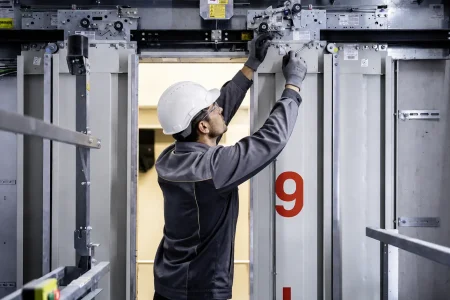 Technicien réalisant la réparation et la modernisation d’un ascenseur